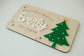 Wooden plaque with 'special Christmas Delivery for Everly' text and a green Christmas tree design on a light background.